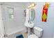 Clean bathroom featuring a pedestal sink, toilet, shower/tub combination, and whimsical wall decorations at 4208 W Bay Vista Ave, Tampa, FL 33611