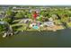 Lakeside property with a pool, dock, and lush greenery set amongst a serene neighborhood and distant cityscape at 5104 Saint Charles Pl, Tampa, FL 33610