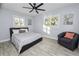Bright bedroom with windows, ceiling fan, accent chair, and queen sized bed at 5104 Saint Charles Pl, Tampa, FL 33610