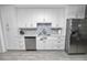 Contemporary kitchen featuring white cabinets, stainless steel appliances, and stylish backsplash at 5104 Saint Charles Pl, Tampa, FL 33610