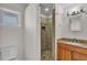 Bathroom features a walk-in shower with stone-look tile and a wood vanity with granite countertop at 923 26Th N St, St Petersburg, FL 33713