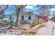 Cozy home featuring a red door, lush landscaping, and a stone walkway leading to the entrance at 923 26Th N St, St Petersburg, FL 33713