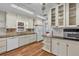 Eat-in kitchen features white cabinets, solid-surface countertops, and stainless steel microwave at 923 26Th N St, St Petersburg, FL 33713