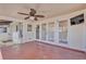 Covered patio with ceiling fan, doors to backyard, and view of pink flowering bushes at 923 26Th N St, St Petersburg, FL 33713