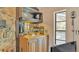 Stylish home bar with a sink, wooden cabinets, open shelving, and elegant mirrored backsplash at 1316 Cambron Dr, Valrico, FL 33596