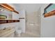 Bathroom featuring a tiled shower, toilet, and a vanity with wood trim at 1316 Cambron Dr, Valrico, FL 33596
