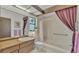 All white tiled bathroom with walk-in shower, white toilet, and wood vanity at 1316 Cambron Dr, Valrico, FL 33596