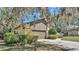 Exterior shot of home with tan walls, brown trim, and lush landscaping at 1316 Cambron Dr, Valrico, FL 33596