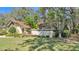 Exterior shot with tan walls, brown trim, grassy yard, and mature landscaping at 1316 Cambron Dr, Valrico, FL 33596