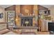 Living room stone fireplace with wooden mantle and hearth, with a wood-paneled accent wall at 1316 Cambron Dr, Valrico, FL 33596