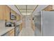 Galley kitchen with stainless steel appliances and light wood cabinetry and tile flooring at 1316 Cambron Dr, Valrico, FL 33596