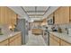 Galley kitchen with stainless steel appliances, ample wood cabinetry and tile flooring at 1316 Cambron Dr, Valrico, FL 33596