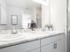 Bathroom with marble countertop, dual sinks, white cabinetry, and a large mirror at 2767 Walden Town Cir, Plant City, FL 33566