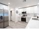 Modern kitchen with stainless steel appliances, white cabinets, and light countertops at 2767 Walden Town Cir, Plant City, FL 33566