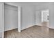 Empty bedroom with closet space and access to other rooms, showing wood-look flooring at 3105 N 17Th St, Tampa, FL 33605