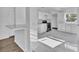 Modern kitchen with white cabinets, stainless steel appliances, and ample counter space on marble-look floors at 3105 N 17Th St, Tampa, FL 33605
