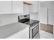 Up close view of the kitchen's stainless steel stove, quartz countertops, and white cabinetry at 3105 N 17Th St, Tampa, FL 33605