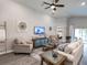 Neutral-toned living room featuring a comfortable seating arrangement, decorative wall art, and hardwood flooring at 7076 162Nd E Pl, Parrish, FL 34219