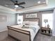 Comfortable main bedroom with neutral colors, a cozy bed, ceiling fan and natural light creating a relaxing atmosphere at 7076 162Nd E Pl, Parrish, FL 34219