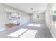 Bright living room showcasing modern neutral colors, new carpet, and a seamless transition to the kitchen at 8630 Mary Ivy Dr, Plant City, FL 33567