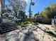 View of the backyard with concrete, overgrown grass, and a dilapidated deck at 921 E 12Th Ave, Tampa, FL 33605