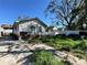Side view of a house with a covered parking area and overgrown yard at 921 E 12Th Ave, Tampa, FL 33605