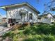 This single-story home showing overgrown grass, gated access, and missing siding at 921 E 12Th Ave, Tampa, FL 33605