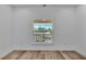 Bright bedroom with a large window offering a clear neighborhood view and hardwood flooring at 12500 Green Oak Ln, Dade City, FL 33525