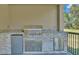 Outdoor kitchen with grill, granite counters, cabinets, and small fridge at 12500 Green Oak Ln, Dade City, FL 33525