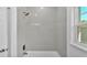 Shower and tub area with white tile and updated fixtures at 12500 Green Oak Ln, Dade City, FL 33525
