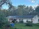 Exterior shot of home; pink with dark roof and surrounding greenery at 3133 Washington Rd, Valrico, FL 33594