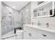 Modern bathroom with gray tile, glass shower, and white double sink vanity with illuminated mirror at 6158 Palma Del Mar S Blvd # 604, St Petersburg, FL 33715
