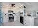 Modern kitchen with white cabinets, stainless steel appliances, and a sleek black dishwasher at 6158 Palma Del Mar S Blvd # 604, St Petersburg, FL 33715