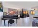 Bright living room with a grand piano, modern lighting fixtures, and expansive windows offering sunset views at 6158 Palma Del Mar S Blvd # 604, St Petersburg, FL 33715