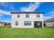 A well-maintained backyard with a lush lawn, a screen door, and a view of the white two-story house at 6914 Quiet Creek Dr, Bradenton, FL 34212