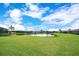 Beautiful backyard featuring a lush green lawn and a tranquil pond surrounded by well-maintained homes at 6914 Quiet Creek Dr, Bradenton, FL 34212