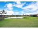 Expansive backyard featuring lush green grass and a serene pond view, perfect for relaxation at 6914 Quiet Creek Dr, Bradenton, FL 34212