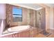 Luxurious bathroom with a soaking tub, tiled walls, and a separate shower area at 6914 Quiet Creek Dr, Bradenton, FL 34212