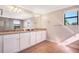 Bathroom with granite countertops, double sinks, white cabinetry and a large mirror at 6914 Quiet Creek Dr, Bradenton, FL 34212