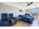 Relaxing bedroom with tile floors, ceiling fan, outdoor view, and comfortable seating at 6914 Quiet Creek Dr, Bradenton, FL 34212