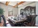 Dining room featuring wooden beams, chandelier, and a glass cabinet with wine and decorative items at 6914 Quiet Creek Dr, Bradenton, FL 34212