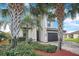 Inviting two-story home with a dark-colored garage door, paver driveway, and neatly landscaped yard at 6914 Quiet Creek Dr, Bradenton, FL 34212