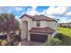 Charming two-story home with a tile roof, arched entry, brick driveway and lush landscaping at 6914 Quiet Creek Dr, Bradenton, FL 34212