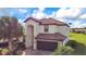 Elegant two-story home with a tile roof, well-manicured landscaping, and a paver driveway at 6914 Quiet Creek Dr, Bradenton, FL 34212