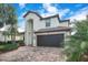 Lovely two-story home with a tile roof, arched entry, brick driveway and mature landscaping at 6914 Quiet Creek Dr, Bradenton, FL 34212