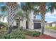 Charming two-story home with a tile roof, palm trees, brick driveway, and a two-car garage at 6914 Quiet Creek Dr, Bradenton, FL 34212