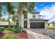 Beautiful two-story home featuring a lush landscaped yard and a brick driveway leading to the dark garage at 6914 Quiet Creek Dr, Bradenton, FL 34212