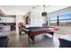 Well-lit game room with a pool table, tile flooring, and a view of the kitchen at 6914 Quiet Creek Dr, Bradenton, FL 34212