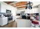 Well-lit kitchen featuring white cabinets, stainless steel appliances, tile backsplash, and a wood-planked ceiling at 6914 Quiet Creek Dr, Bradenton, FL 34212