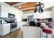 Bright kitchen featuring modern appliances, a stylish breakfast bar, and a unique wooden ceiling at 6914 Quiet Creek Dr, Bradenton, FL 34212